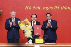 Prime Minister Pham Minh Chinh (right) and Permanent Deputy Prime Minister Nguyen Hoa Binh (left) present a decision appointing Nguyen Quoc Doan as Standing Deputy Inspector General of the Government Inspectorate. (Photo: VNA)