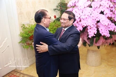 Prime Minister Pham Minh Chinh (right) and former General Secretary Nong Duc Manh (Photo: VNA)