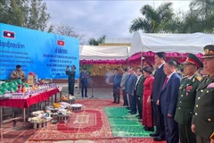 Delegates from Vietnam and Laos observe a minute of silence to commemorate the heroic martyrs of the two nations. (Photo: VNA)