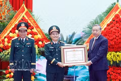 Party General Secretary and State President To Lam (right), who is also Secretary of the Central Military Commission, presents the "Hero of the People’s Armed Forces" title to representatives of Military Region 3 on April 10. (Photo: VNA) 
