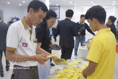Participants learn about products displayed by Cambodian businesses at the seminar. (Photo: VNA)