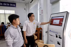 A civil servant at the Public Administrative Service Centre of Long Xuyen ward, An Giang province, assists a resident in completing online procedures via the National Public Service Portal. (Photo: VNA)