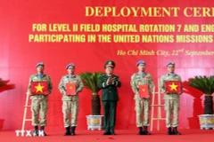 On behalf of the State President, Deputy Minister of National Defence Senior Lieutenant General Hoang Xuan Chien Hoang Xuan Chien presents the decision to Vietnamese units assigned to UN peacekeeping missions and hands over the national flag to them. (Photo: VNA)