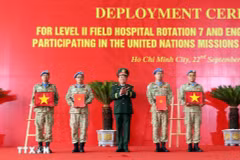 On behalf of the State President, Deputy Minister of National Defence Senior Lieutenant General Hoang Xuan Chien Hoang Xuan Chien presents the decision to Vietnamese units assigned to UN peacekeeping missions and hands over the national flag to them. (Photo: VNA)