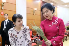 The spouse of Party General Secretary To Lam, Ngo Phuong Ly (R), introduces the spouse of visiting Japanese Prime Minister Ishiba Shigeru, Ishiba Yoshikoand, to the art of making Hanoi’s famed 'banh com'. (Photo: VNA)