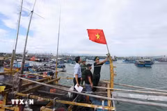 Border guards inspect vessel monitoring equipment on a fishing boat before it heads out to sea. (Photo: VNA)