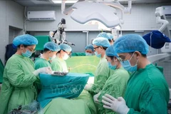 Doctors observe a minute of silence to pay tribute to the organ donor. (Photo: published by VNA)