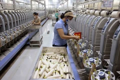 Workers at a yarn production line. (Photo: VNA/VNS)