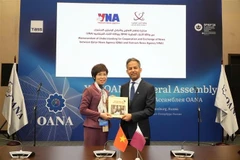 VNA General Director Vu Viet Trang (L) introduces the photo book "100 Years of Vietnam's Revolutionary Press (1925–2025)" to an international friend. (Photo: VNA)