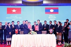 Minister of Industry and Trade Nguyen Hong Dien and his Lao counterpart Malaithong Kommasith sign the Vietnam - Laos Trade Agreement on April 8, 2024. (Photo: VNA)