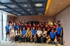 Ambassador Ta Van Thong (fourth, left, front row) staff of the Vietnamese Embassy, and the Vietnamese community in Indonesia pose for a group photo with the Vietnam U23 men's football team. (Photo: VNA)
