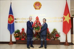 Anouphap Toulalom, Party Central Committee member and Secretary of Vientiane Party Committee, presents flowers to Vietnamese Ambassador to Laos Nguyen Minh Tam (R) to offer congratulations on the 80th National Day of Vietnam (September 2, 1945 – 2025). (Photo: VNA)