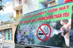 A banner on the side of a car urges people to quit smoking for their own health and that of their loved ones (Photo: VNA)