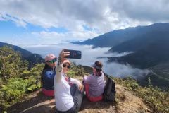 Tourists experience the Divine Rock tour in La Pan Tan commune, Mu Cang Chai district, Yen Bai province. (Photo: VNA)
