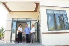 A revolution contributor is happy to get a new home built under the housing support programme. (Photo: VNA)