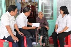 Representatives of the Party Committee, People's Council, People's Committee, and Vietnam Fatherland Front Committee of Phu Loi Ward in Ho Chi Minh City present gifts from the Party and State to a beneficiary at her home on the occasion of the 2026 New Year. (Photo: VNA)