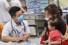 A doctor examines a child during a medical check-up in HCM City. (Photo: VNA)
