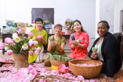 Visitors experience the traditional craft of scenting tea with Quang An lotus flowers. (Photo: VNA)
