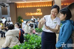 A Vietcombank employee guides a client in biometric process (Photo: qdnd.vn)