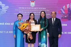 Cuban Consul General in Ho Chi Minh City Ariadne Feo Labrada (second, left) receives the “For peace and friendship among nations” insignia of the Vietnam Union of Friendship Organisations at the event (Photo: VNA)