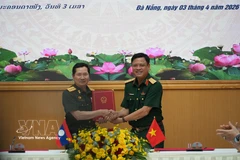 Sen. Lieut. Gen. Nguyen Truong Thang, Deputy Minister of National Defence of Vietnam (right) and Sen. Lieut. Gen. Saichay Kommasith, Deputy Minister of National Defence and Chief of the General Staff of the Lao People’s Army exchange the minutes of the dialogue. (Photo: VNA)