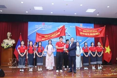 Ambassador Nguyen Minh Tam presents the first prize to the team from the National University of Laos' School of Gifted and Ethnic Students at the contest. (Photo: VNA)