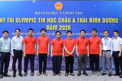Vietnamese students competing at the 2026 Asia-Pacific Informatics Olympiad (in red shirts) pose for a photo with their teachers. (Photo: Ministry of Education and Training)