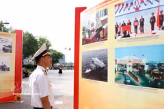 A visitor looks at photos featuring people and landscape of Vietnam (Photo: VNA)