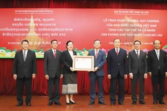 Vietnamese Ambassador to Laos Nguyen Minh Tam presents the first-class Independence Order to the Lao Presidential Office. (Photo: VNA)