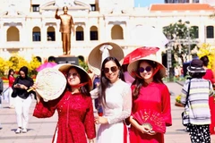 Overseas Vietnamese in traditional ao dai explore Nguyen Hue flower street. (Photo: qdnd.vn)