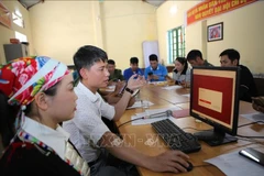 Residents of Son Ha village, Bat Xat commune, Lao Cai province are learning how to submit applications online through the public service portal. (Photo: VNA)