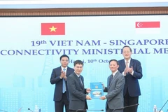 Vietnamese Minister of Finance Nguyen Van Thang (first, left) and Singaporean Minister-in-Charge of Energy, and Science and Technology in the Ministry of Trade and Industry Tan See Leng (first, right) witness the signing ceremony of three cooperation agreements between the two sides. (Photo: baochinhphu.vn)