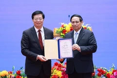 Prof. Dr. Qiu Yong (L), Secretary of the Tsinghua University’s Party Committee and Academician of the Chinese Academy of Sciences presents the "Honorary Professor" title to PM Pham Minh Chinh. (Photo: VNA)