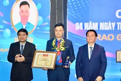Nguyen Trong Nghia, Politburo member, Secretary of the Party Central Committee and Head of the Party Central Committee’s Commission for Information, Education and Mass Mobilisation (R) and Nguyen Dac Vinh, Chairman of the National Assembly’s Committee for Culture and Education, present the Ly Tu Trong Award. (Photo: The HCYU Central Committee) 