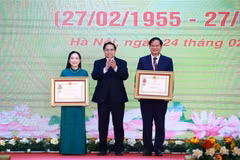 Prime Minister Pham Minh Chinh (C) presents the third-class Labour Order to Associate Professor Dr. Dao Xuan Co, Director of Bạch Mai Hospital, and the Meritorious Doctor title to Nguyen Thi Mai Ngoc, a doctor at the Vietnam National Heart Institute under Bach Mai Hospital. (Photo: VNA)