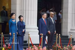Party General Secretary and State President To Lam and Singaporean President Tharman Shanmugaratnam, together with their spouses, stand on the podium of honour as military bands perform the national anthems of Vietnam and Singapore at the welcome ceremony on May 29 morning. (Photo: VNA) 