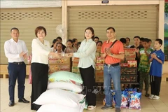 Pham Thi Minh Huong (second, left), Chairwoman and General Director of Gold Phuc Company, presents gifts to students at the school for the visually impaired under Thongpong Eye Hospital in Sikhottabong district, Vientiane capital, on February 28 (Photo: VNA)