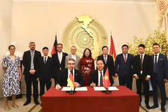 Vietnamese Deputy Minister of Industry and Trade Nguyen Hoang Long (front, right) and Parliamentary State Secretary at the German Ministry for Economic Affairs and Energy Stefan Rouenhoff signed the joint declaration in the presence of Vice State President Vo Thi Anh Xuan (standing, sixth from left). (Photo: VNA)