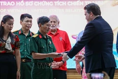 US Ambassador to Vietnam Marc Evans Knapper hands over wartime artifacts to families of fallen soldiers and veterans. (Photo: VNA)