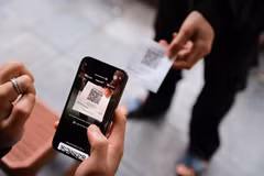 A customer is making payment via QR code at a coffee shop. The Ministry of Finance has proposed new regulations on taxable revenue thresholds for household businesses. (Photo: VNA)