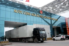 Vehicles carrying goods clear customs through Mong Cai (Vietnam) - Dongxing (China) border gate at Bac Luan II bridge area. (Photo: VNA)