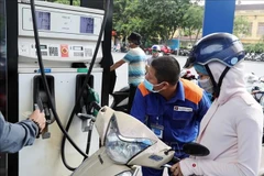 Customers buy petrol at a Petrolimex station in Hanoi (Photo: VNA)