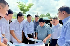 Deputy Prime Minister Nguyen Chi Dung (front, third from right) inspects the Provincial Road DT.975 project on April 21. (Photo: VNA)