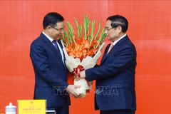 PM Pham Minh Chinh presents congratulatory flowers to Acting Minister of Industry and Trade Le Manh Hung. (Photo: VNA)