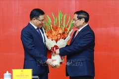 PM Pham Minh Chinh presents congratulatory flowers to Acting Minister of Industry and Trade Le Manh Hung. (Photo: VNA)