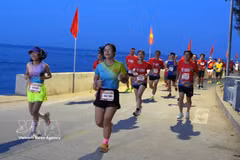 Runners experiencing a windy coastal road during the Ly Son Half Marathon 2026. (Photo: VNA)