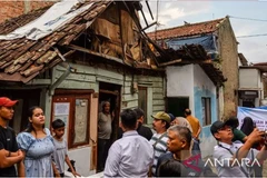 Residents walk in front of uninhabitable houses in Pagarsih, Bandung, West Java, Indonesia, on May 3. (Photo: ANTARA)