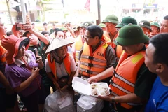 Prime Minister Pham Minh Chinh visits and encourages people affected by floods in Phan Dinh Phung ward of Thai Nguyen province. (Photo: VNA)