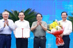 PM Pham Minh Chinh (second from right) presents the Decision approving HCM City's master planning scheme to its leaders. (Photo: VNA)