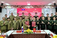 The Quang Tri Border Guard Command and the police of Laos' Salavan province sign the minutes of their annual talks on December 26. (Photo: released by VNA)